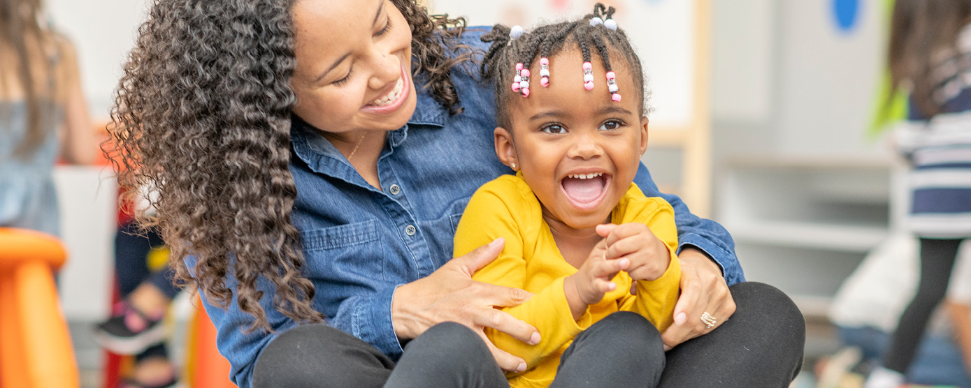 woman holding and hugging a happy small child