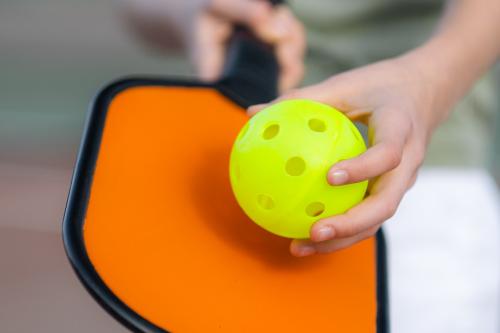 closeup shot of pickleball paddle and ball in serve position